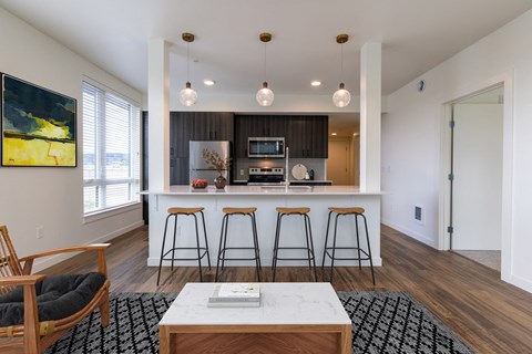 a kitchen with a large island and four stools in front of a counter top